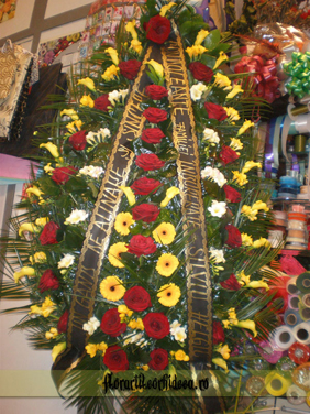 Coroana din cale galbene, frezii albe si galbene si trandafiri rosii